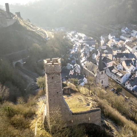 Luftaufnahme von Monreal mit einer Burg im Vordergrund und Fachwerkhäusern im Tal. Die Landschaft ist von Bäumen und Hügeln umgeben., © Eifel Tourismus GmbH, D. Ketz Luftaufnahme von Monreal mit einer Burg im Vordergrund und Fachwerkhäusern im Tal. Die Landschaft ist von Bäumen und Hügeln umgeben., © Eifel Tourismus GmbH, D. Ketz