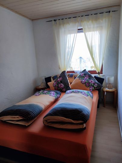 Schlafzimmer mit einem Queensize-Bett, (bei bedarf zwei Beistellbetten) und großem Kleiderschrank.