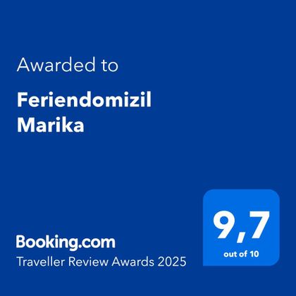 Ein Auszeichnungsschild für das Feriendomizil Marika mit einer Bewertung von 9,7 von 10. Verliehen von Booking.com für die Traveller Review Awards 2025.