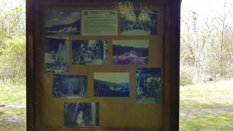Ein Informationsschild mit mehreren Fotos von Landschaften und Natur. Die Bilder zeigen verschiedene Aussichtspunkte und Szenen aus der Umgebung.