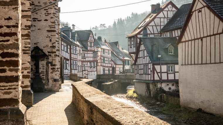 Eine malerische Altstadt mit Fachwerkhäusern und einem ruhigen Kanal. Die sanfte Morgenbeleuchtung schafft eine gemütliche Atmosphäre.
