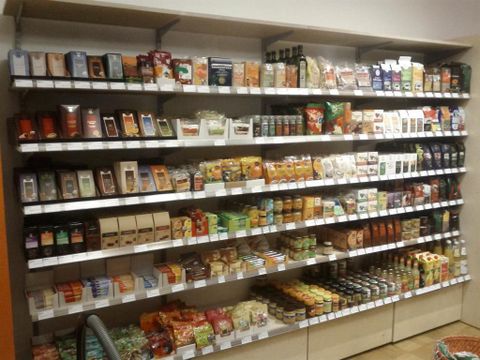Ein gut sortiertes Regal mit verschiedenen Lebensmitteln. Die Produkte umfassen Snacks, Getränke und Trockenwaren.