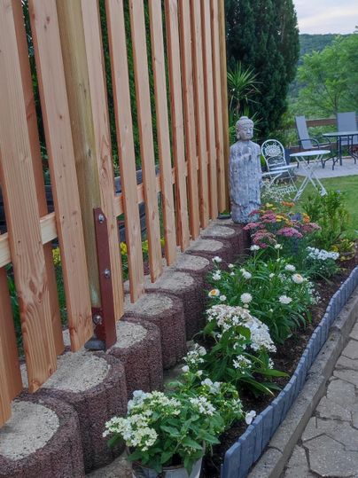 Ein gepflegter Garten mit Blumenbeeten und dekorativen Elementen.