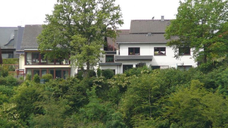 Ein ruhiges Wohngebiet mit mehreren Häusern, umgeben von grüner Vegetation. Bäume erhöhen die natürliche Schönheit der Umgebung.