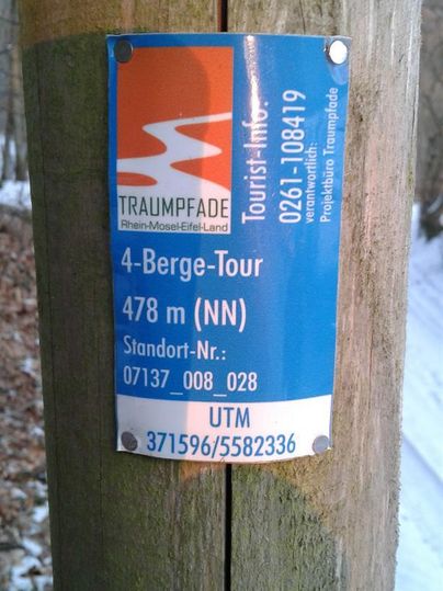 An information sign about the 4-Mountains-Tour with an elevation of 478 m. It is located on a wooden post outdoors.