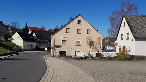 A quiet street view with several houses. The sky is clear and blue, creating a friendly atmosphere.