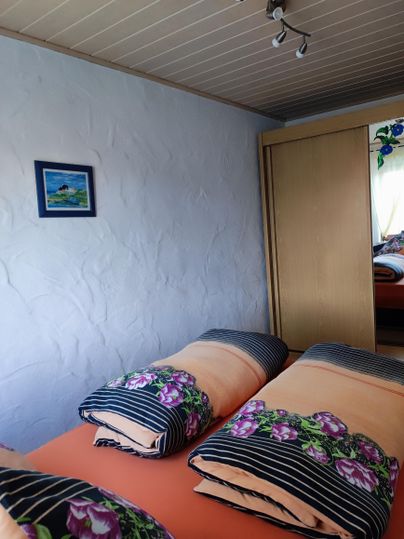Schlafzimmer mit einem Queensize-Bett, (bei bedarf zwei Beistellbetten) und großem Kleiderschrank.