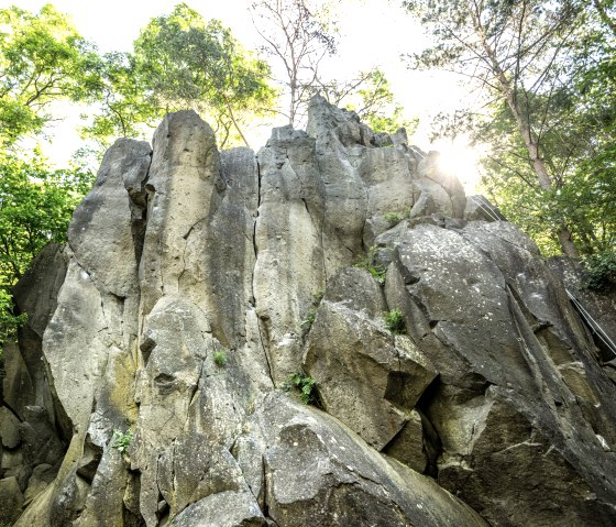 Bizarre Felsformation im Kottenheimer Winfeld, umgeben von dichtem Wald. Sonnenlicht scheint durch die B&auml;ume., &copy; Eifel Tourismus GmbH, Dominik Ketz
