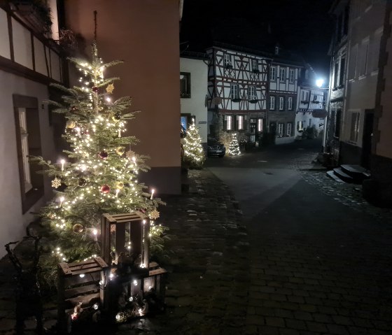 Weihnachtlich beleuchtete Gasse mit Fachwerkh&auml;usern und geschm&uuml;ckten Tannenb&auml;umen bei Nacht., &copy; Svenja Schulze-Entrup