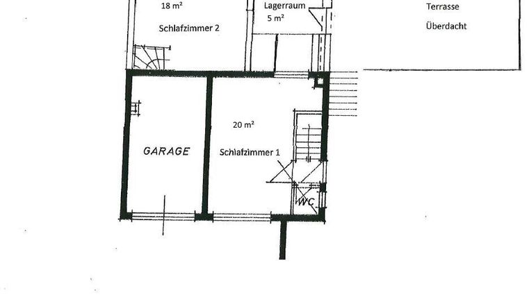 Grundriss eines Erdgeschosses mit einer Garage und zwei Schlafzimmern. Der Plan zeigt auch einen Lagerrraum und ein WC.