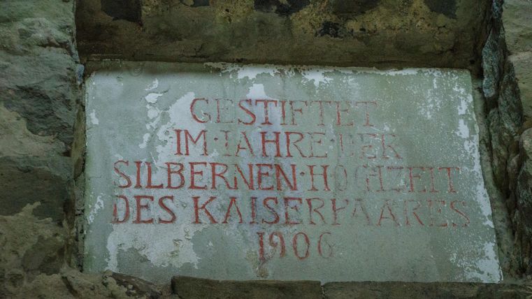 Ein historischer Stein mit einer Inschrift. Die Jahreszahl 1906 und der Hinweis auf die Silberne Hochzeit des Kaiserpaares sind deutlich sichtbar.
