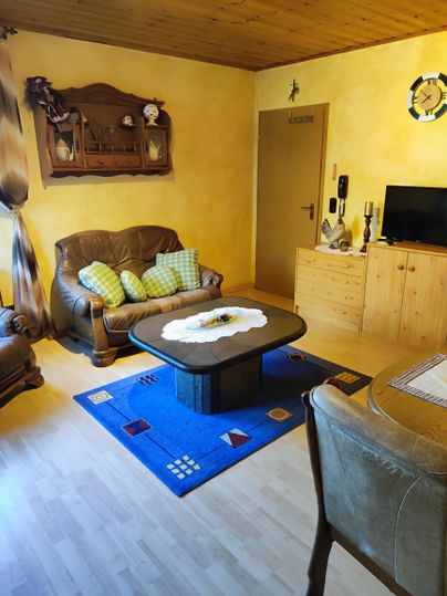 Ein gemütliches Wohnzimmer. Genießen Sie entspannte Stunden auf dem bequemen Sofa nach einem erlebnisreichen Urlaubstag. Für Ihre Unterhaltung steht ein Smart-TV bereit. Die angrenzende, großzügige Essecke lädt zu gemeinsamen Mahlzeiten oder geselligen Spieleabende ein.
