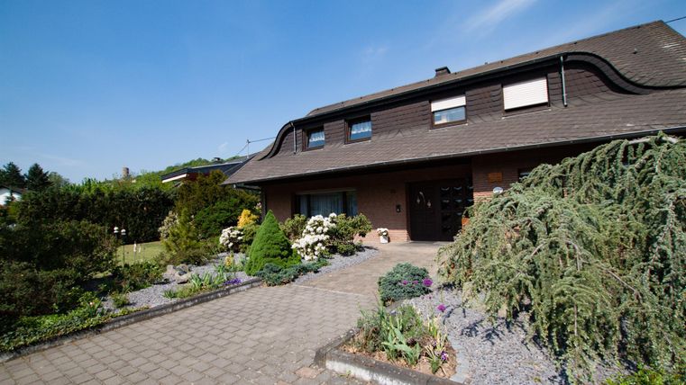 Ein modernes Haus mit einem gepflegten Garten. Die Umgebung ist grün und einladend.