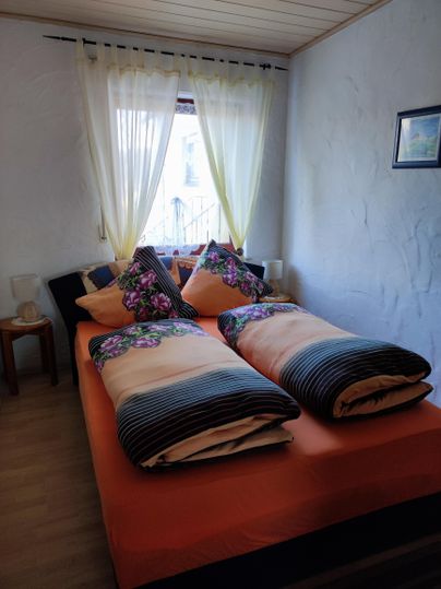 Schlafzimmer mit einem Queensize-Bett, (bei bedarf zwei Beistellbetten) und großem Kleiderschrank.
